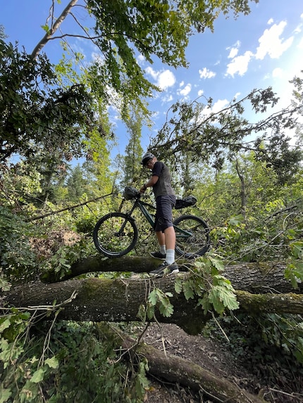 Ein Mann, sein E-Bike und ein Balanceakt im Wald.