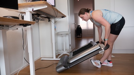 Le câble d'alimentation gêne et doit être débranché pour qu'Anne puisse ranger le WalkingPad à la verticale.