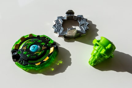 The three components of a Beyblade: Attack Ring, Weight Disk and Blade Base.