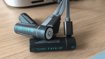 The USB to Micro USB-C cable in use: while charging, the batteries flash; once charged, the light changes to a solid green.