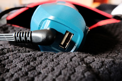 Cette batterie est portée en permanence. Un port USB est également présent.