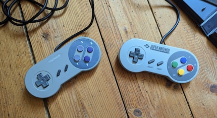 Der Third-Party-Controller (links) fühlt sich noch billiger an als das Original. Dafür funktioniert die Start-Taste.