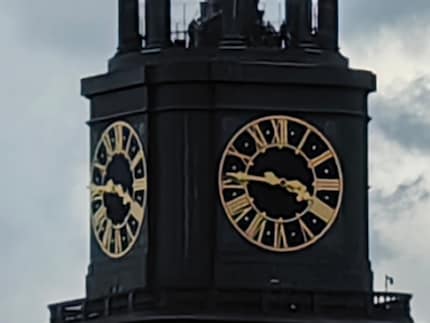 Der fünfzigfache Zoom holt die Kirchturmuhr ins Bild, aber wirklich schön sieht sie so nicht aus.
