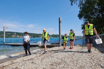 Helpers aan wal houden de bubbels van de duikteams in de gaten en ruimen de kust op.