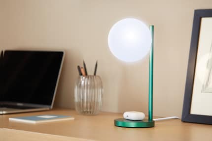 De lamp voor op kantoor laadt ook draadloos je mobiel of koptelefoon op.