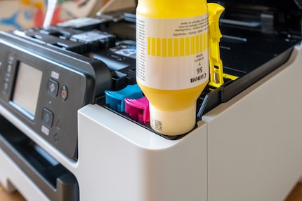 Die Flasche kommt kopfüber auf den Drucker. Das Befüllen läuft bei allen Modellen gleich ab.