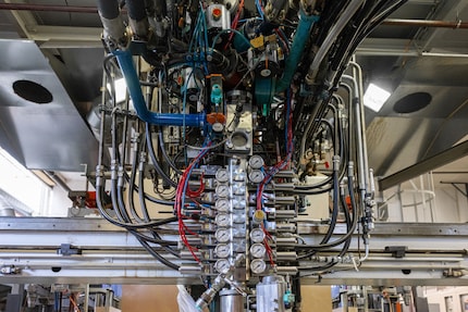Une machine digne H.R. Giger injecte la pâte du gâteau en mousse sur une bande.