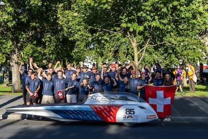 Photo de groupe avec la voiture de course solaire.