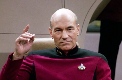 Patrick Stewart als kapitein Jean-Luc Piccard met de Starfleet speld op zijn borst.