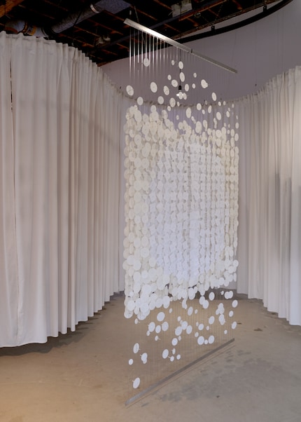 The double-sided room divider «Metamorphosis» consists of stainless steel cords with movable paper shapes.