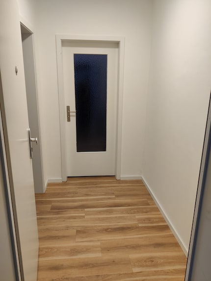 Een blik op de lege gang vanaf de voordeur.
