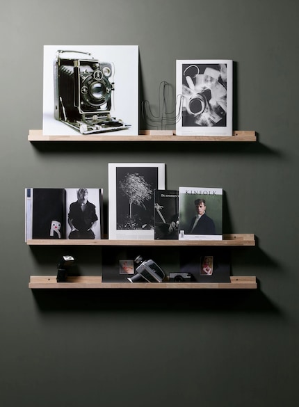 Three vertically arranged picture ledges bring structure to a bare wall.