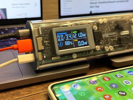 Twee MacBooks en een smartphone worden tegelijkertijd opgeladen.