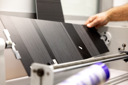 Le fil est tendu sur un plateau noir pour détecter les éventuels défauts.