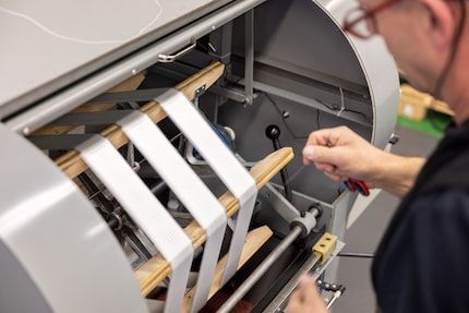 Une machine aligne soigneusement les fils.