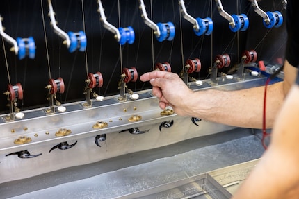 Une personne enfile les cocons, une machine les déroule entièrement.