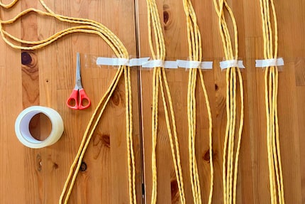 The masking tape’s not strong enough, so I attach the yarn with a second layer of adhesive tape. Better safe than sorry.