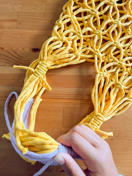 I wrap the purple yarn around the yellow with a strong tug. Unfortunately, I have to repeat this several times.