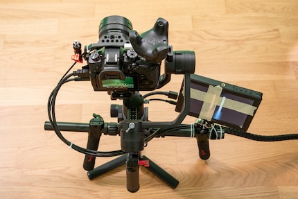 Camera met gimbal en gemonteerde tracker. De uitvoer van het scherm is opgesplitst in vier delen. De tape vestigt de aandacht op het deel rechtsonder waar alles aan elkaar is genaaid.