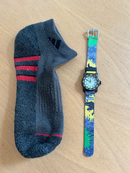Eerst stop ik het horloge in een kous...