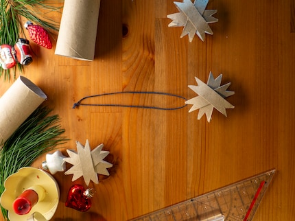 Mit der Schnur wird der Stern an den Christbaum gehängt. 