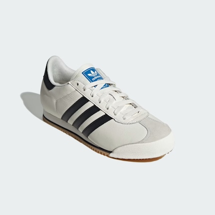 The Adidas K 74 in classic white with black stripes.