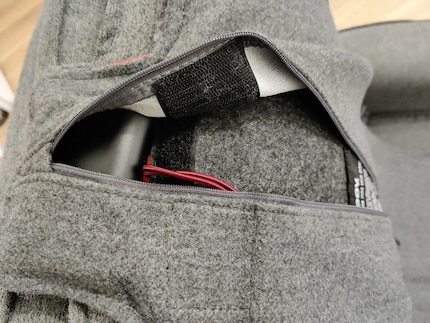 It’s the bulge on the top right and can be accessed via a zip.