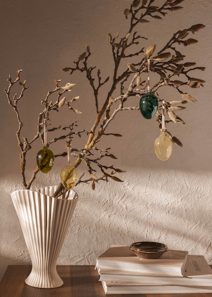 An eye-catcher: the Easter shrub in a pleated vase combines elegance and spring-like lightness.