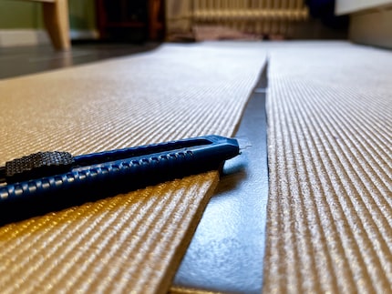 Het tapijtmes glijdt gemakkelijker door de mat dan ik had verwacht. Zo gemakkelijk zelfs dat de snijranden een beetje scheef worden. Oeps.