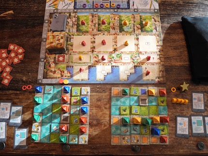 On the game board, I collect the materials with which I build my city districts (two building sites can be seen below).