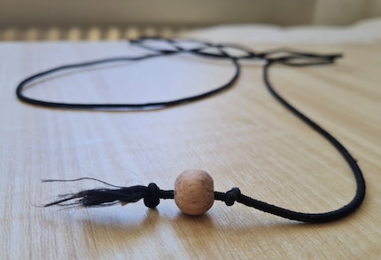 Meine abgewandelte Version für Jasper: eine Holzperle statt Maus an der Gummischnur.