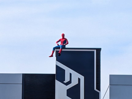 Groet vanaf het dak: Een Disney medewerker in een Spiderman kostuum.