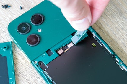 De batterij is bevestigd met vier schroeven en een plug-in connector.