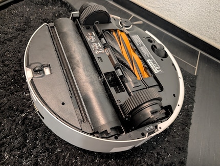Als de robot het tapijt stofzuigt, ligt de rol onder een flap.